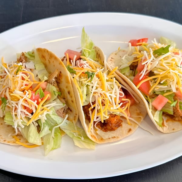 Three delicious José's Torta Mexicana tacos filled with meat, lettuce, tomatoes, and cheese.