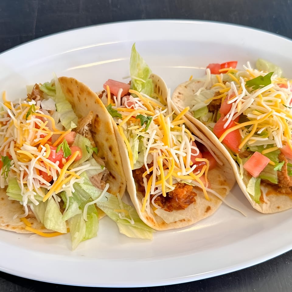 Three delicious José's Torta Mexicana tacos filled with meat, lettuce, tomatoes, and cheese.